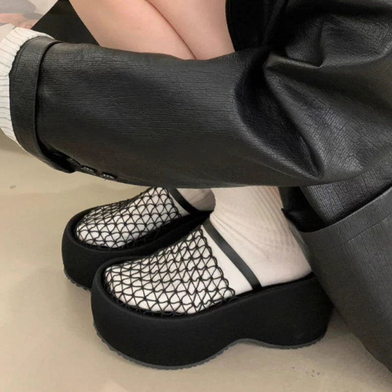 Woman wearing black mesh platform wedge sandals with white socks