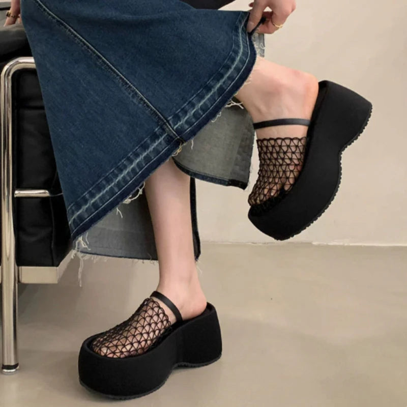 Side view of women’s black mesh platform wedge sandals with denim skirt